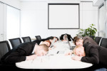 Executives asleep at a conference table
