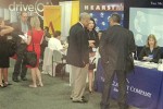 Handful of journalists standing near job fair booths at convention
